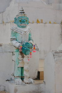 Statue against wall and building