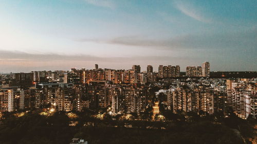 High angle view of illuminated buildings against sky at night