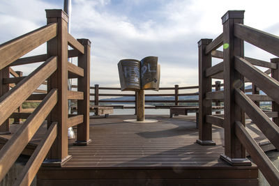 Empty chairs and tables against sky