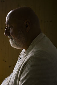 Side view of sad man with shaved head at home