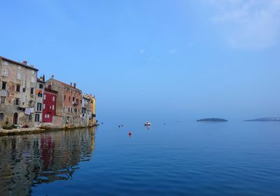 Scenic view of sea by buildings against sky