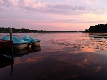 Scenic view of swimming pool by lake against sky during sunset