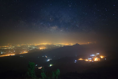 Illuminated city against sky at night