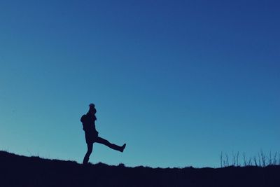 Silhouette woman against clear blue sky