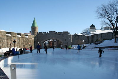 Group of people ice-skating in city during winter