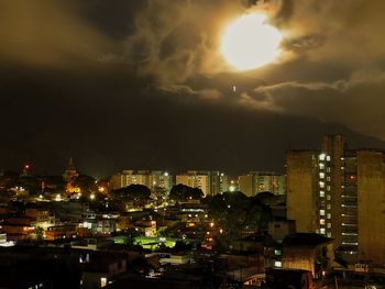 Illuminated cityscape against sky at night