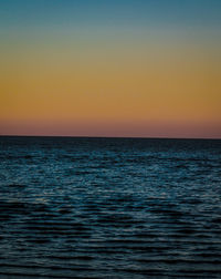 Scenic view of sea against clear sky during sunset