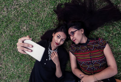 Portrait of smiling young woman using mobile phone outdoors