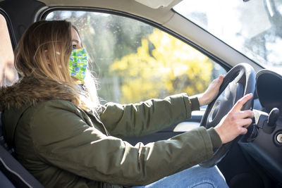 Side view of woman sitting in car