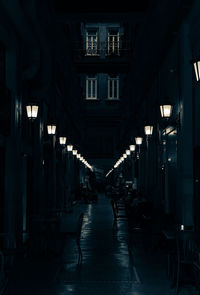 Empty hallway amidst buildings in city at night