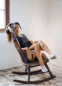 Portrait of woman sitting on chair at home