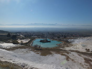 Aerial view of sea and cityscape against sky