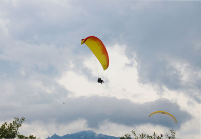 Low angle view of person paragliding against sky