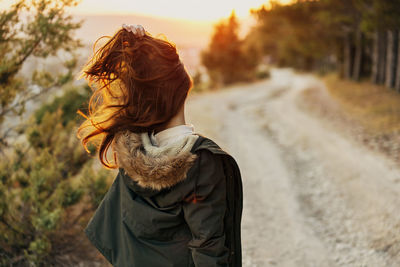 Rear view of woman standing on road