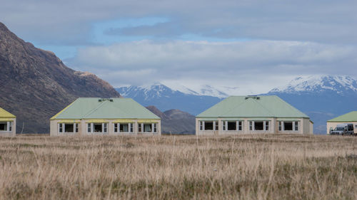 Houses on field against sky