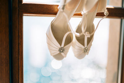 Low angle view of decoration hanging against window at home