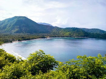 Scenic view of sea and mountains against sky