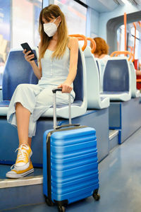 Woman using mobile phone while sitting in train