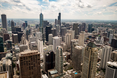 Aerial view of cityscape against cloudy sky