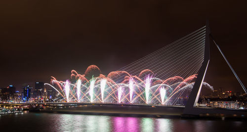 Illuminated bridge over river at night