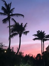 Silhouette palm trees against romantic sky at sunset