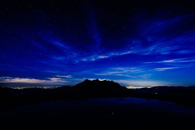 Scenic view of silhouette mountains against sky at night