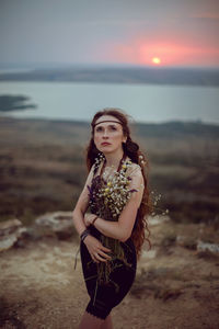 Young woman lies in nature in a black dress