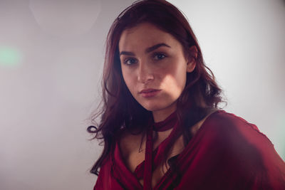 Portrait of beautiful young woman against white background