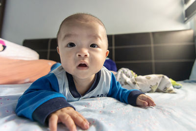 Portrait of cute boy lying on bed