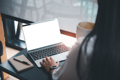 High angle view of woman using laptop on table