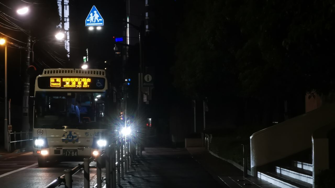 night, transportation, darkness, illuminated, mode of transportation, light, architecture, city, lighting, sign, bicycle, street, road, land vehicle, street light, built structure, vehicle, midnight, headlight, building exterior, evening, communication, road sign, motor vehicle, city life, car, infrastructure, travel, guidance, no people, text, lane, automotive lighting, lighting equipment, public transportation, outdoors, city street, the way forward, motion, rail transportation, information sign, symbol