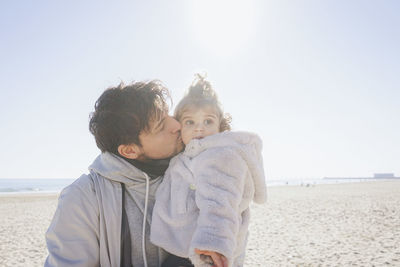 Father kissing daughter at beach