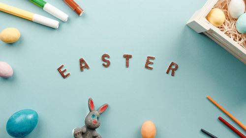 Easter text on a blue background with colored eggs