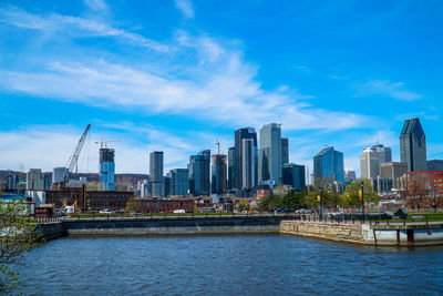 City at waterfront against cloudy sky