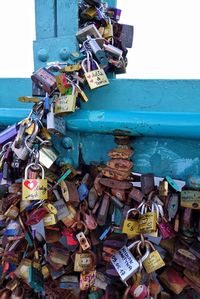 Close-up of padlocks hanging on railing by bridge