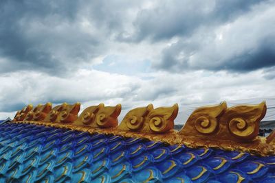 Low angle view of multi colored roof against sky