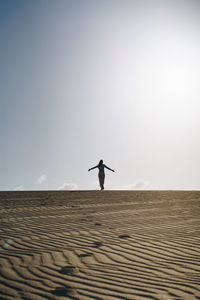 Full length of man standing on street against clear sky