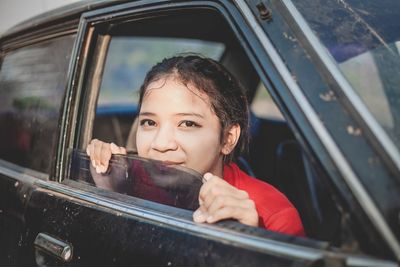 Close- up portrait of young beautiful women sitting a car.