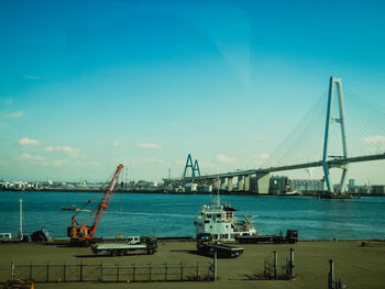 View of suspension bridge over sea against sky