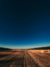 Scenic view of agricultural field against clear blue sky