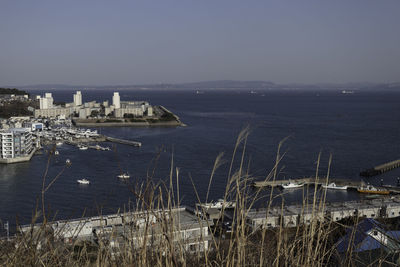 High angle view of buildings by sea against clear sky