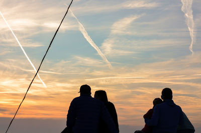 Rear view of silhouette people against sky during sunset