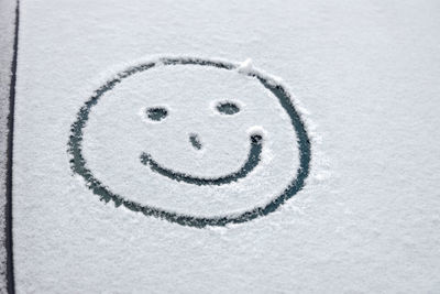 Close-up of smiley face on snow