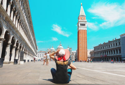 Low angle view of people walking in front of clock tower