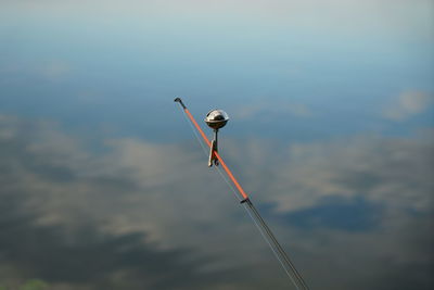 Low angle view of bird perching on street light