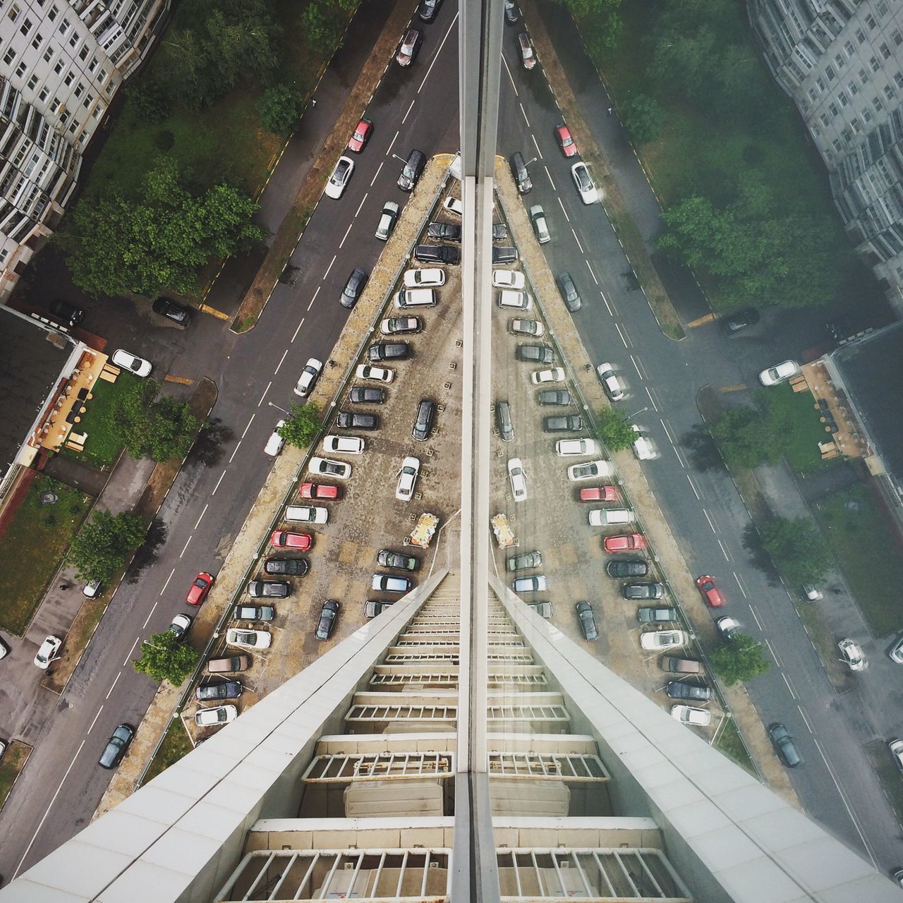 high angle view, transportation, architecture, built structure, building exterior, city, the way forward, diminishing perspective, vanishing point, railroad track, tree, road, city life, outdoors, street, elevated view, connection, no people, rail transportation, mode of transport