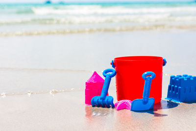 Close-up of red toys on beach