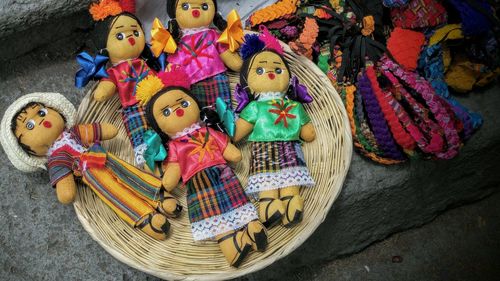 Close-up of multi colored dolls in a wicker basket