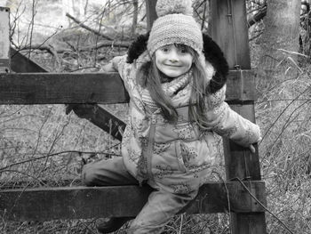 Portrait of smiling girl siting on railing