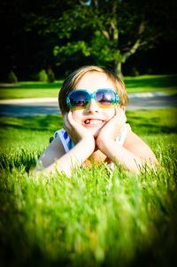 Portrait of happy girl standing on grassy field